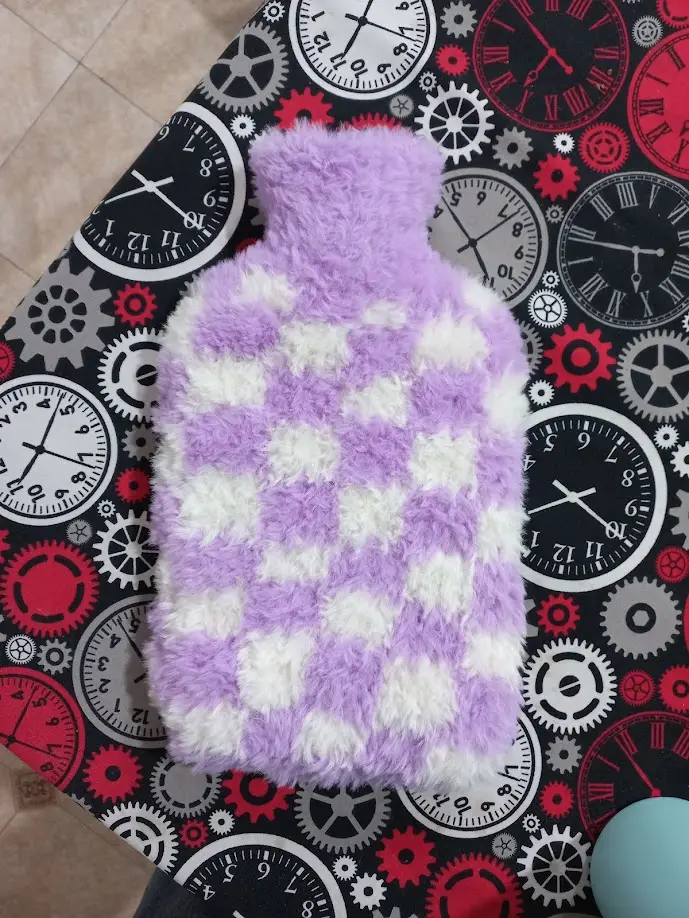 This is a freestyle knitted hot water bottle cover/sleeve 😍. Made from bottom up: basically you cast on a number of stitches (divisible by 4 if you want to make the checkerboard pattern, that was 44 in my case) and knit across (I used cable needles) until you reach the narrow upper part of the bottle. Then you start decreasing (alternating with only knit rows so that it isn't too abrupt). The upper part is only knit rows. It's intuitive!
